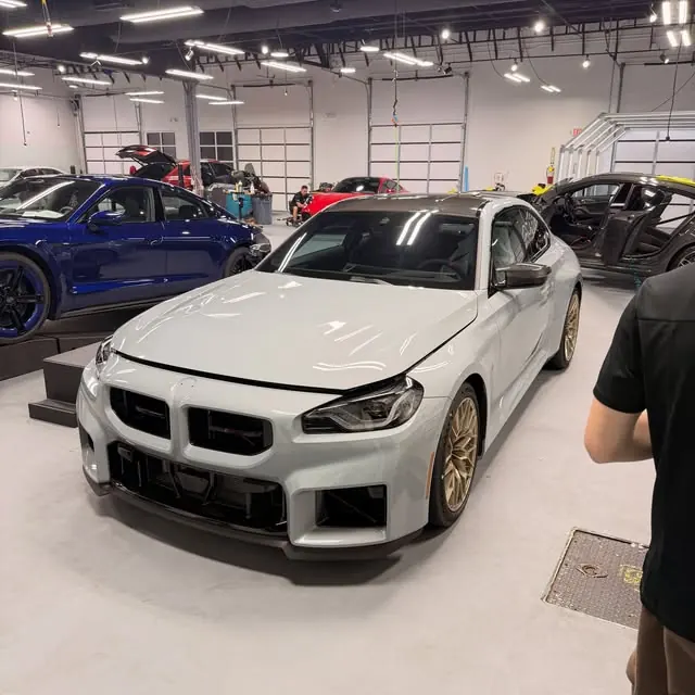 White performance sedan at an indoor shop